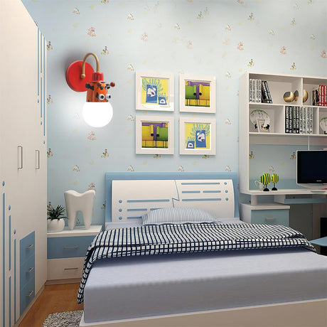 The tiger lamp lit on the wall of a kids bedroom beside framed pictures and a bed