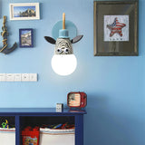 The zebra lamp lit on a blue wall above a low shelf and framed prints