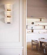 Three blocks lit on a white paneled wall beside a doorway to a dining room