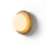 The lit fitting seen at an angle, the globe clear of the softened wood edge