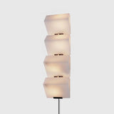 The four block lamp on a plain wall, each block set slightly off the one below