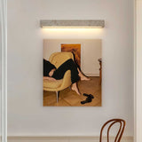 Travertine bar lit above a framed painting beside a bentwood chair