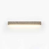 Solid travertine bar on a wall, a warm slot of light running along its lower edge