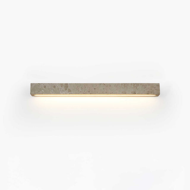 Solid travertine bar on a wall, a warm slot of light running along its lower edge