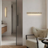 Travertine bar lit on a bathroom wall with a second bar upright beside the doorway