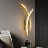 The crossed arms lit above a nightstand with vases beside a bed