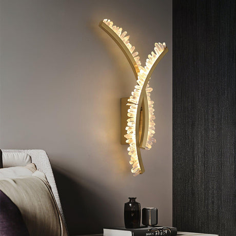 The crossed arms lit above a nightstand with vases beside a bed