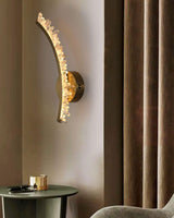 One curved arm lit beside a brown curtain above a small side table