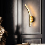 One curved arm lit on a black paneled wall beside a classical bust