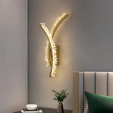 The crossed arms lit beside a channel tufted headboard with a green pillow