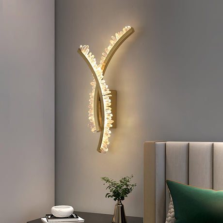 The crossed arms lit beside a channel tufted headboard with a green pillow