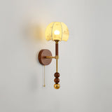 Amber cut glass shade lit on a tall walnut column with brass fittings