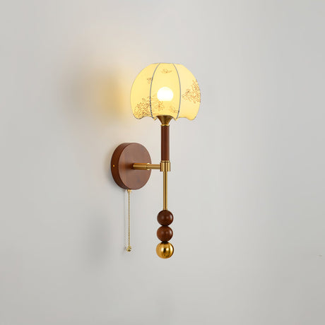 Amber cut glass shade lit on a tall walnut column with brass fittings
