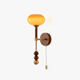 Wall sconce for a stairway with an amber glass tulip shade on a walnut column