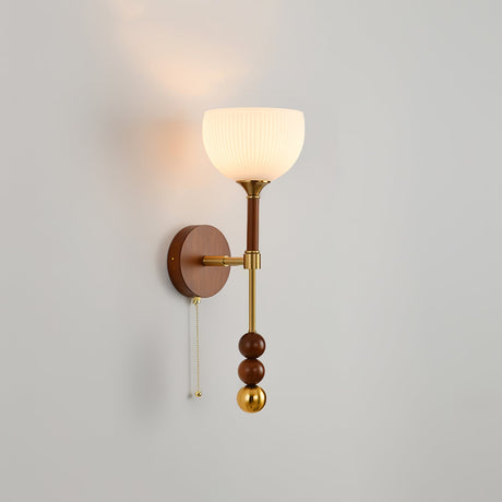 White glass bell shade on a tall walnut column with brass rings and a pull chain