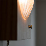 Close view of the lens throwing a soft beam across the wall beside it