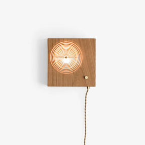Wall sconce with a cord, a ribbed glass lens set in a cherry wood box