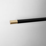Close view of the rod end, a black tube finished with a small gold cap