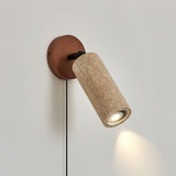 The travertine barrel turned down on its joint, a small pool of light below it