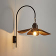 The petal shade lit from beneath, the filament lamp showing under it