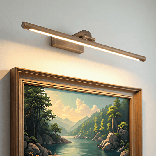 Gold bar lit above a gilt framed landscape painting on a pale wall