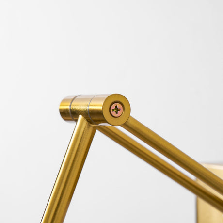 Close view of the knurled joint where the arm pivots against the gold tube
