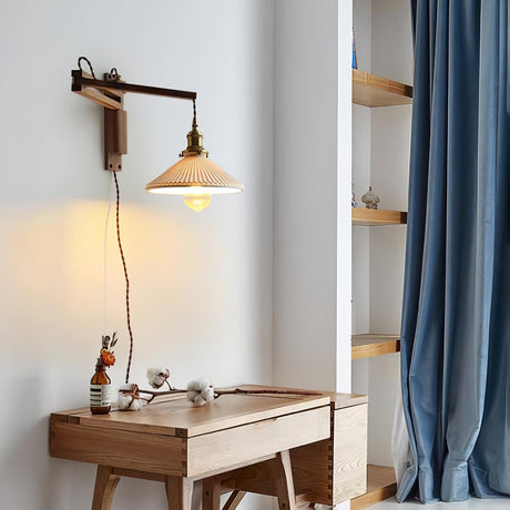 The swing arm lamp lit above a wood desk beside a blue curtain