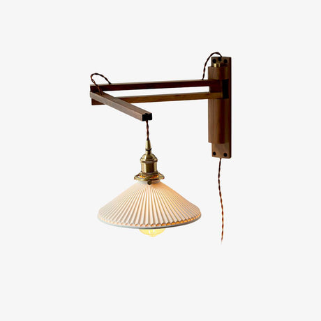 Walnut wall lamp with a folding swing arm and a pleated white ceramic shade on a brass socket