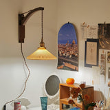 The curved arm version lit above a small vanity table in a bedroom
