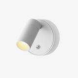 A small white puck spotlight with a tilting barrel and a button on the face