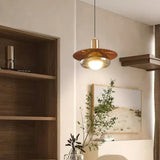 The walnut grain disc lit beside open shelves and a trailing plant