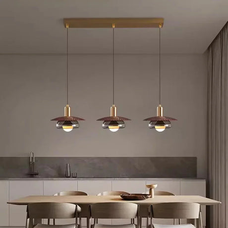 Three walnut grain discs lit in a row above a pale dining table