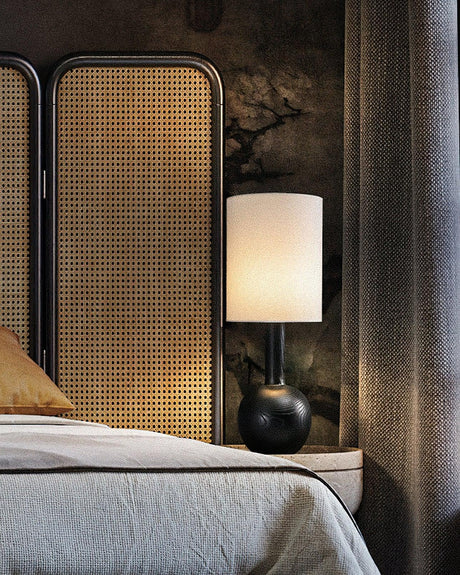 The black version lit on a nightstand in a dim bedroom