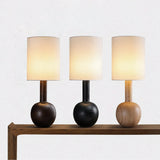 The three finishes of the walnut table lamp lined up on a console