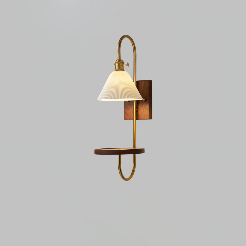 White shade above a walnut shelf carried on a slim brass loop