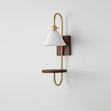 White shade and walnut shelf on a brass loop, seen from the side