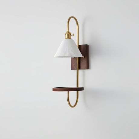 White shade and walnut shelf on a brass loop, seen from the side