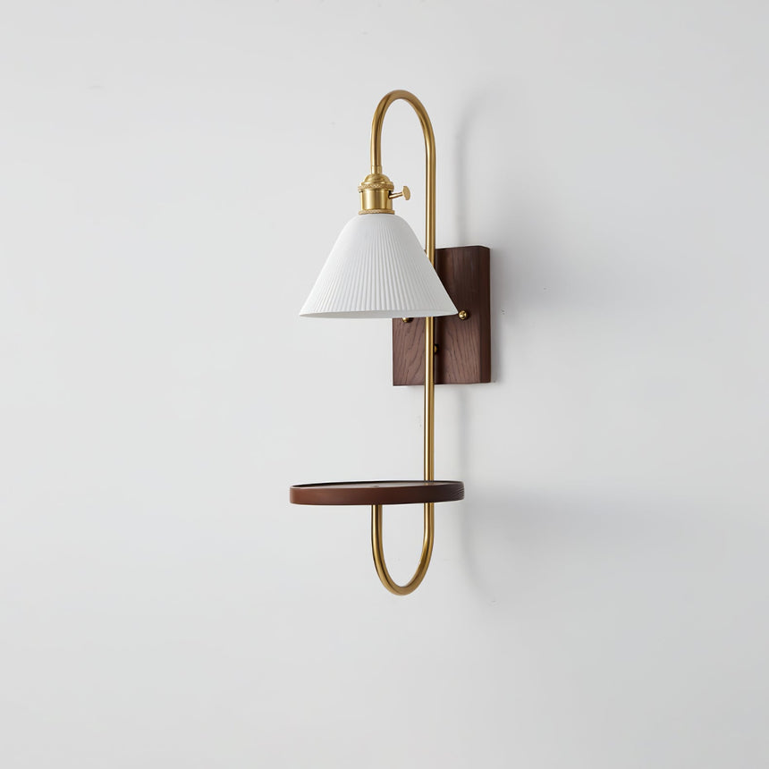 White shade and walnut shelf on a brass loop, seen from the side
