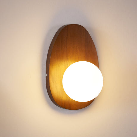 The teardrop plate lit warm, the globe glowing against the walnut grain