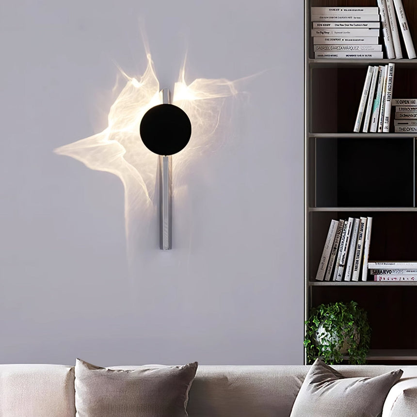 The single disc light lit above a sofa beside a bookshelf