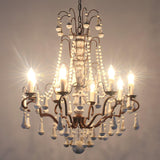 The chandelier lit warm, showing the column, the arms and the bead drops