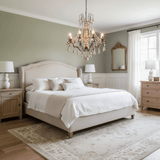 Lit in a bedroom above an upholstered bed with nightstands and a gold mirror