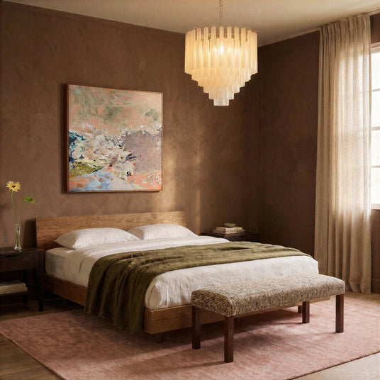 The fitting lit above a bed with a bench at its foot and a framed painting
