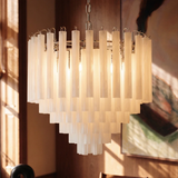 The frosted tubes lit close beside a large framed painting on a brown wall