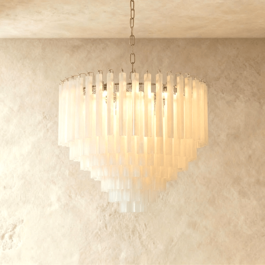 A stepped cone of frosted glass tubes lit warm under a slim chrome frame