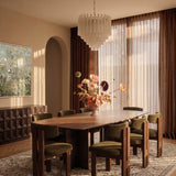 The fitting lit in the evening above the same dining table and green chairs