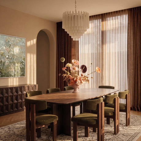 The fitting lit in the evening above the same dining table and green chairs