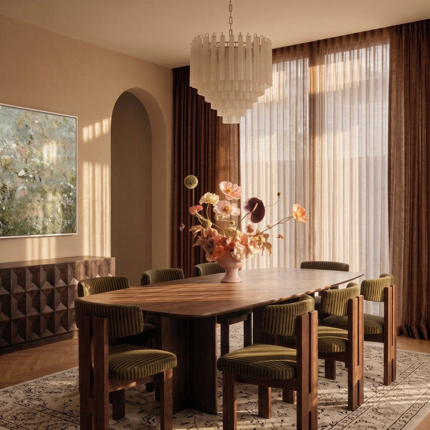 The fitting lit in the evening above the same dining table and green chairs