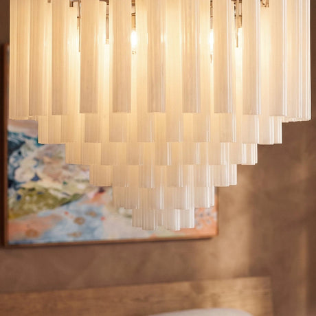 The stepped rows of frosted tubes lit in front of a pale framed canvas