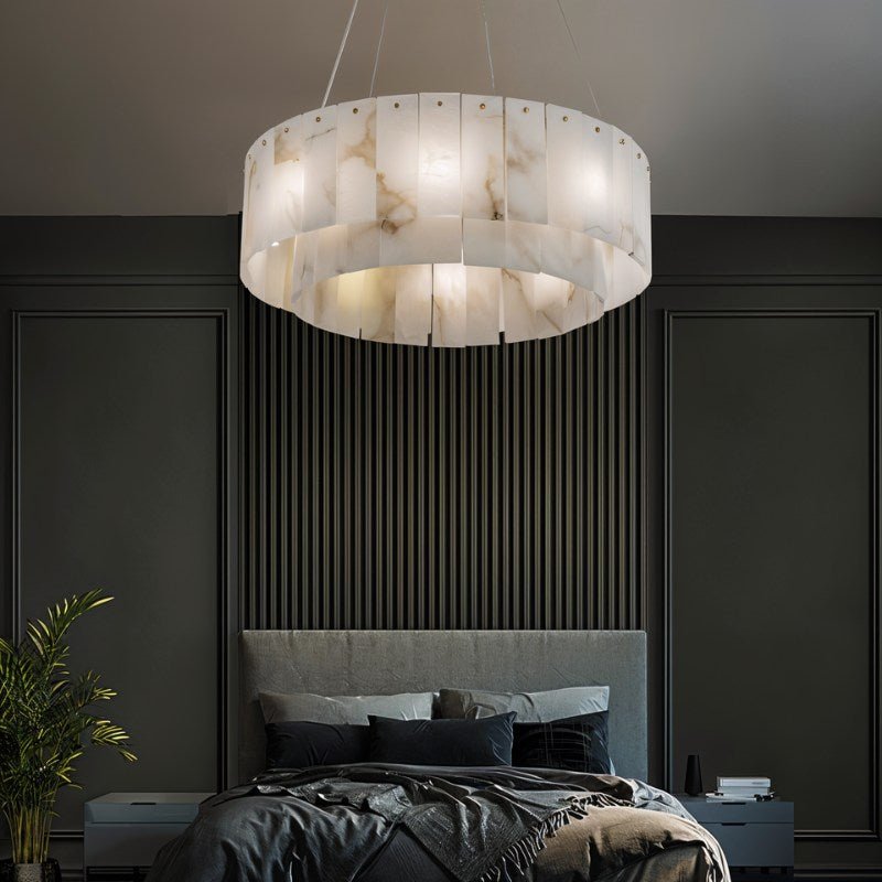 The lit drum in a bedroom above a bed with a paneled wall and a plant